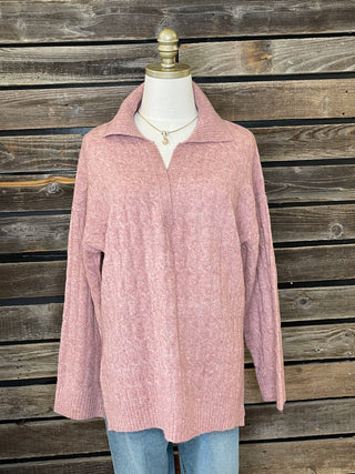 Pink sweater on a mannequin against a wooden background