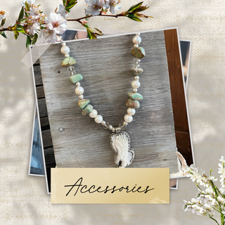 Necklace with a decorative pendant on a wooden card labeled 'Accessories', surrounded by white flowers.